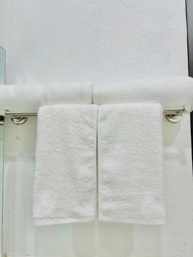 two white towels hanging on a towel rack in a bathroom at The Mountain Homestay & Cafe in Văn Lâm