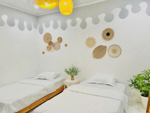 two beds in a room with hats on the wall at The Mountain Homestay & Cafe in Văn Lâm