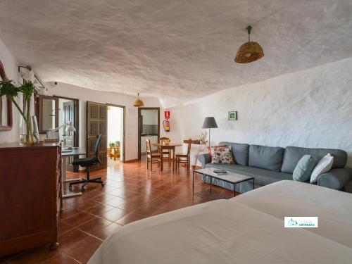 a living room with a blue couch and a table at Living Artenara - CAVE HOUSE & SILENCE Adults Only in Artenara