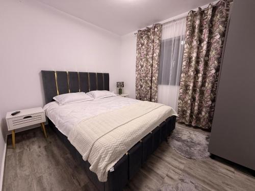 a bedroom with a bed and a window with curtains at Casa Maxi in Gherla