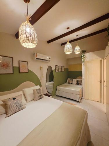 um quarto com duas camas e duas luminárias pendentes em Solar Águas Pipa Stays em Pipa