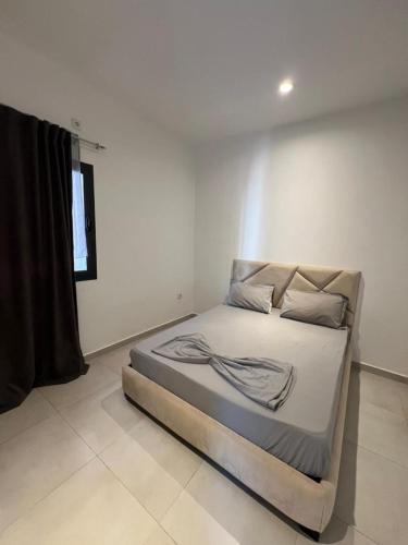 a bedroom with a bed in a white room at Résidence Guebbas in Skikda