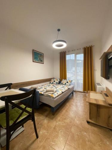 a bedroom with a bed and a table and a window at Apartmani Resna Budva in Budva