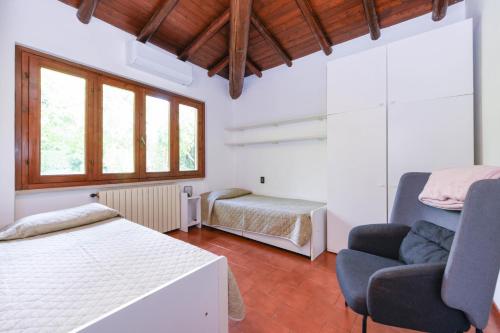 a bedroom with a bed and a couch and a chair at Villa Maria by Garda FeWo in Moniga