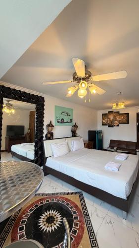 a bedroom with two beds and a ceiling fan at Fully Furnished Omni Tower Apartments Nana - Sukhumvit soi 4 in Bangkok