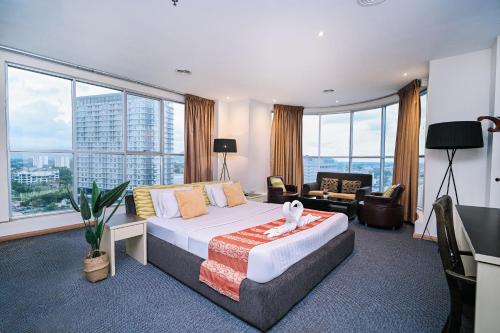 a bedroom with a large bed and a room with windows at Kingston Hotel 15 - Tower Regency, Ipoh in Ipoh