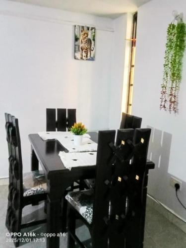 a black dining room table with black chairs at Shalom Stays in Machakos
