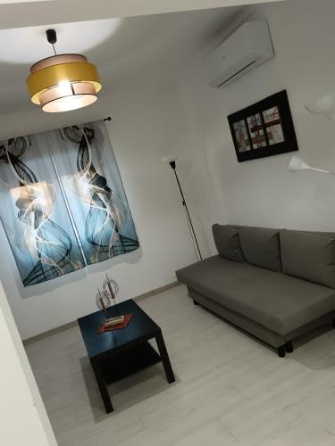 a living room with a couch and a table at Cantinho Familiar a 10 minutos do Aeroporto in São João da Talha