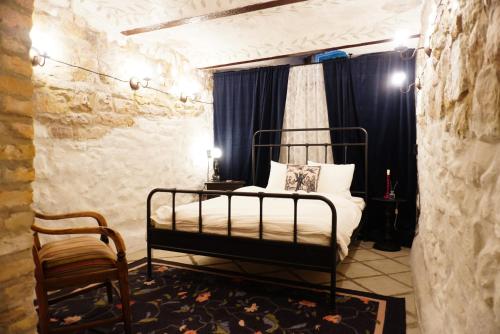 a bedroom with a bed and a chair at Witch House Apartment in Rīga