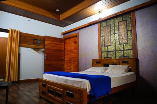 a bedroom with a bed with a large window at The Rain Tree resort in Kutta