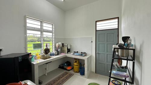 a kitchen with a counter and a sink and a door at AS Suria Homestay Banglo 1 Tingkat Kota Bharu in Kota Bharu