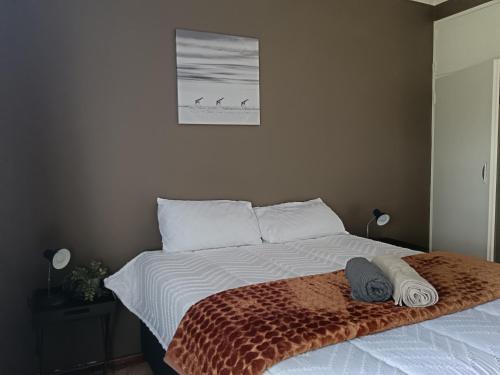 een slaapkamer met een bed met twee handdoeken erop bij 179 Guesthouse on Mountain Drive in Mbabane
