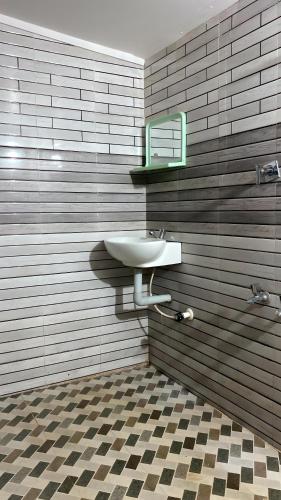 a bathroom with a sink and a mirror at The Rain Tree resort in Kutta