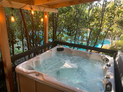 eine Whirlpool-Badewanne auf einem Balkon mit Bäumen in der Unterkunft Cabañas Natural Park Lodge Pucón in Pucón