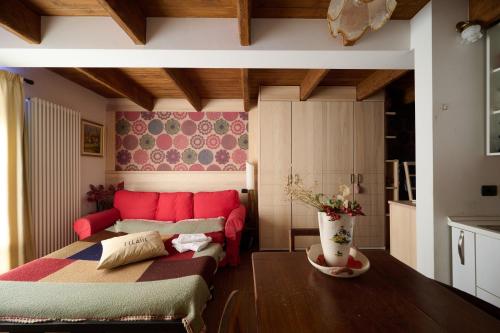 a bedroom with a bed and a red couch at Mono 1400 in Limone Piemonte