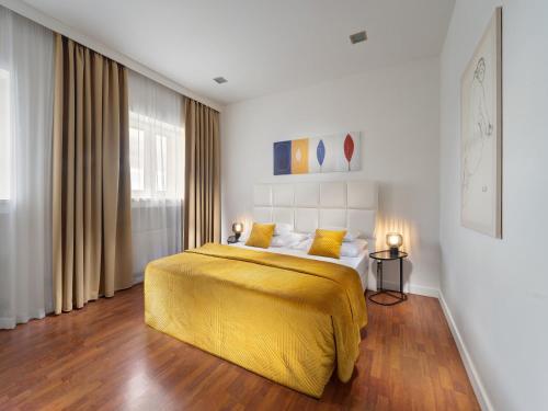 ブラチスラヴァにあるMamaison Residence Sulekova Bratislavaの黄色い毛布が掛けられたベッドのある寝室