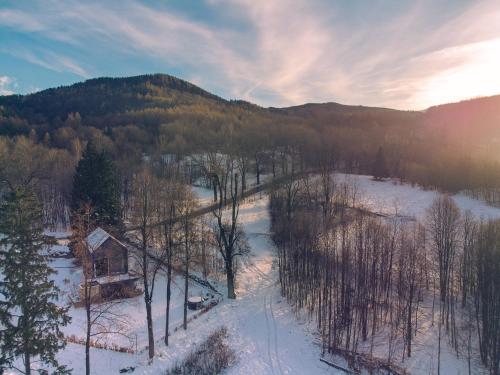 an aerial view of a snow covered forest with a cabin at Rest Hill -Domek z balią i sauną - Everslow in Sosnówka