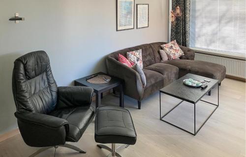 3 Bedroom Cozy Home In Bøvlingbjerg في Bøvlingbjerg: غرفة معيشة مع أريكة بنية وكرسيين