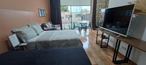 a bedroom with a bed and a flat screen tv at Apê Estúdio Rodrigues 01 in Paranaíba
