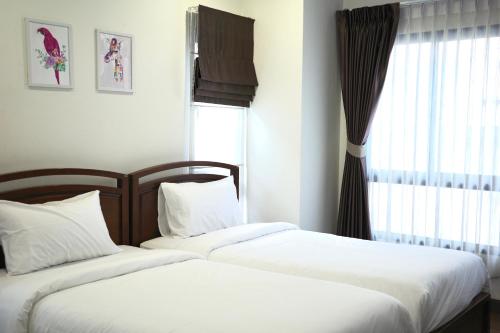 2 Betten neben einem Fenster in einem Schlafzimmer in der Unterkunft Pool villa Aonang 2 room 2 bedroom in Ao Nang Beach