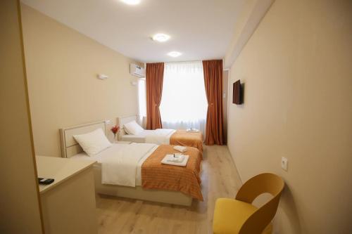 a hotel room with two beds and a window at Hotel Caucasus in Tbilisi City
