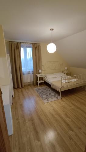 a bedroom with a bed and a table and a window at Willa Kumat in Brańsk