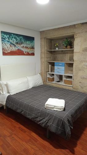 a bedroom with a large bed with a gray blanket at La Guinda Real- Centro histórico in Vigo