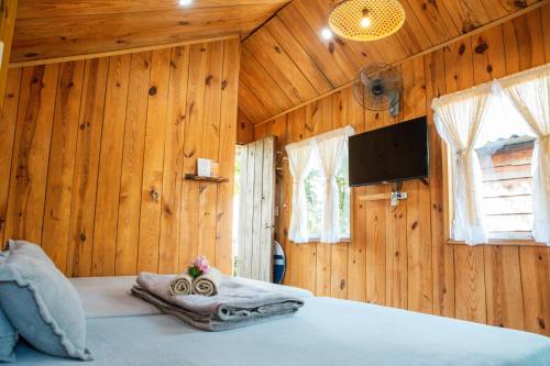 ein Schlafzimmer mit Holzwänden und ein Bett in einem Zimmer in der Unterkunft September Garden Homestay in Da Lat