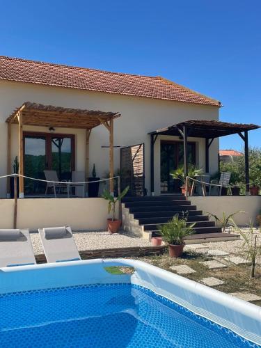 a villa with a swimming pool in front of a house at Maçussa Country House in Massuça