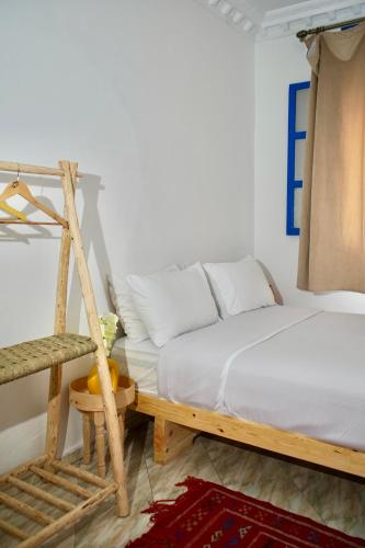 a white bedroom with a bed and a ladder at Onda Surf in Taghazout