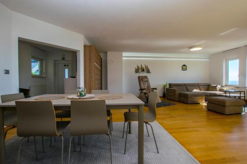 a dining room and living room with a table and chairs at Apartmani BILIC in Kastav