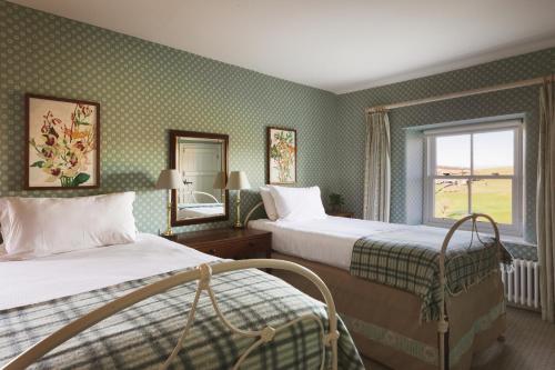 a hotel room with two beds and a window at Wharfe View Cottage Bolton Abbey Estate in Skipton
