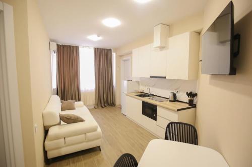 a living room with a couch and a kitchen at Hotel Caucasus in Tbilisi City