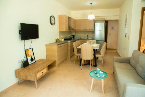 a living room with a couch and a table and a kitchen at Eukalyptos 3BD apartment with yard in Chersonisos in Hersonissos
