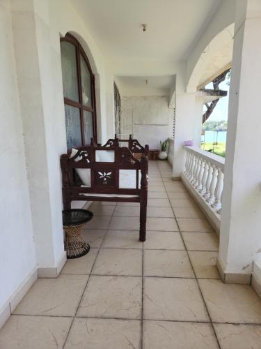 a room with a bench sitting on a tiled floor at Creek apartment in Kilifi