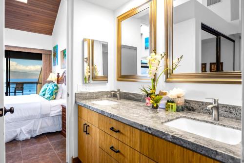 a bathroom with two sinks and a bedroom with a bed at KBM Resorts FREE CAR Sands of Kahana Ocean view 3-Bedroom Condo Penthouse Recently Remodeled SOK-292 in Kaanapali