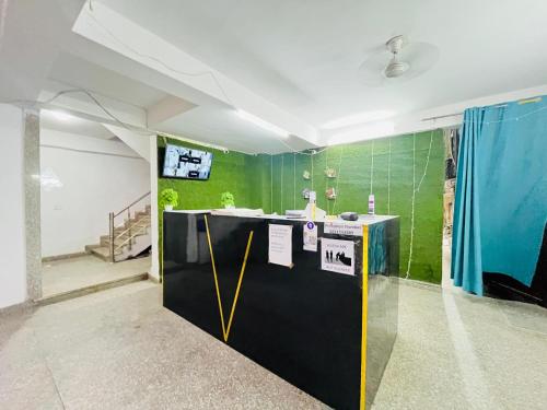 Una habitación con un mostrador negro y amarillo y paredes verdes. en Hotel 24 Stay - Near Max Hospital, en Nueva Delhi