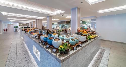 Una línea de buffet con jarrones y frutas en un vestíbulo. en Crowne Plaza Muscat by IHG, en Mascate