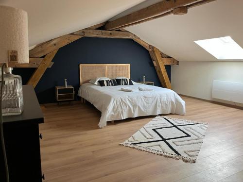 ein Schlafzimmer mit einem großen Bett im Dachgeschoss in der Unterkunft Les Gîtes du Colombier in Ollé