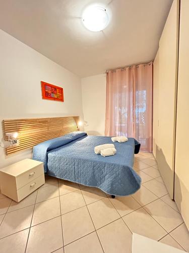 a bedroom with a blue bed and a window at Galliano Flexrent - Immobiliare Abissinia in Riccione