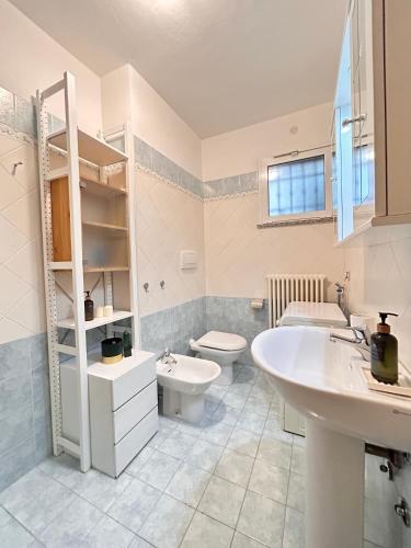 a white bathroom with a sink and a toilet at Galliano Flexrent - Immobiliare Abissinia in Riccione