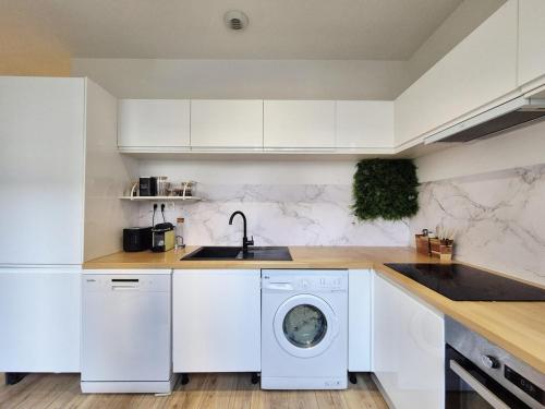 a kitchen with a washing machine and a sink at La Pause Briochine in Saint-Brieuc