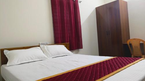 Seetha Residency في تيروفانمالي: غرفة نوم بسرير وستارة حمراء