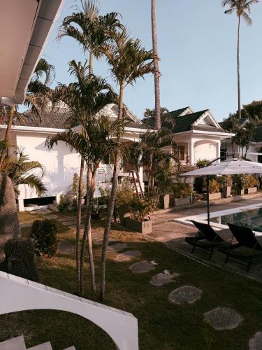 a resort with palm trees and a swimming pool at The Rai Resort Rawai - Pool & Garden in Ban Bang Chak