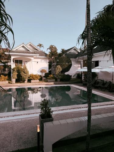 a swimming pool in front of a house at The Rai Resort Rawai - Pool & Garden in Ban Bang Chak