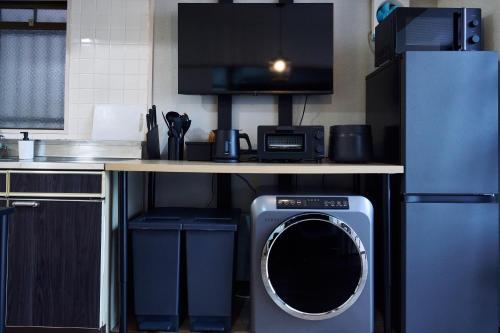 een keuken met een wasmachine onder een aanrecht bij New Open! Central Kobe 最大9名 三宮,元町,中華街,北野へアクセス抜群 長期宿泊設備充実 in Kobe