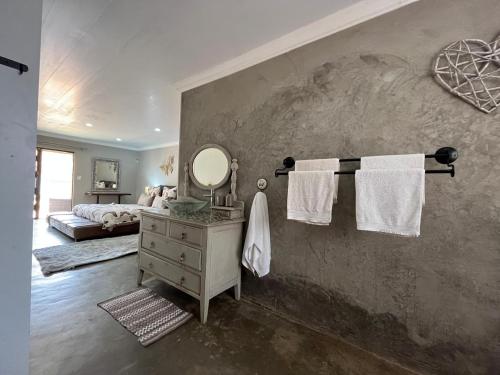 a bathroom with a mirror and towels on a wall at Lavender Lane in Denysville