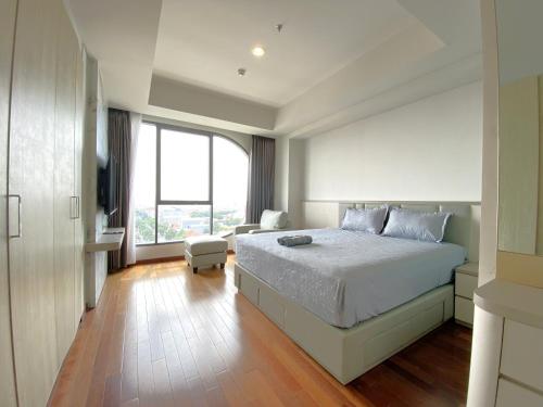 a bedroom with a large bed and a large window at Signature 2BR Apartment ARC100 Vasa Suite Surabaya City Centre with Balcony by Le Ciel Hospitality in Surabaya