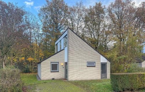 a small brick house in the middle of a yard at Three Bedroom Nice Home In Hoeven in Hoeven