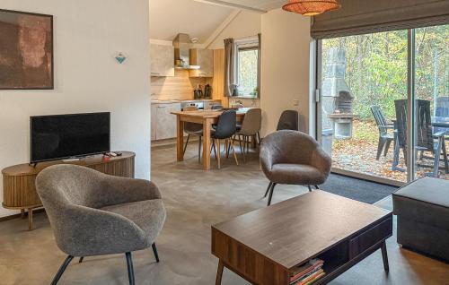 a living room with chairs and a table and a kitchen at Three Bedroom Nice Home In Hoeven in Hoeven